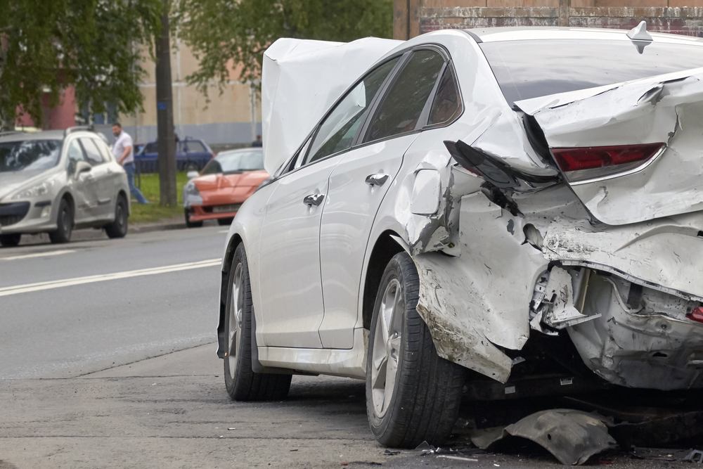 Rear-end collision involving a damaged white sedan, highlighting when to hire an Anaheim car accident lawyer after a serious crash.