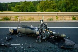 Damaged motorcycle and debris scattered across the road after a collision