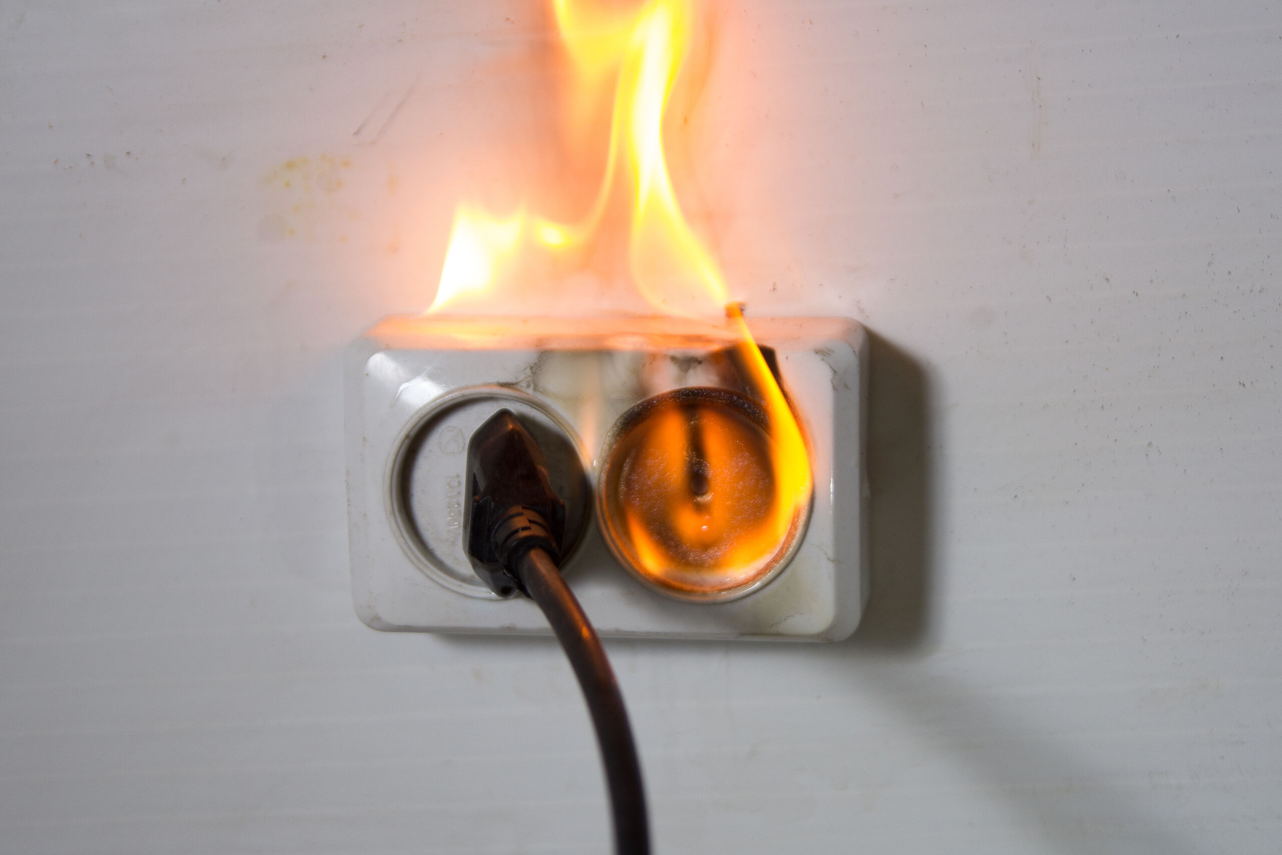 Electrical wall outlet catching fire from a defective plug illustrating cases handled by Burbank product liability accident lawyers.