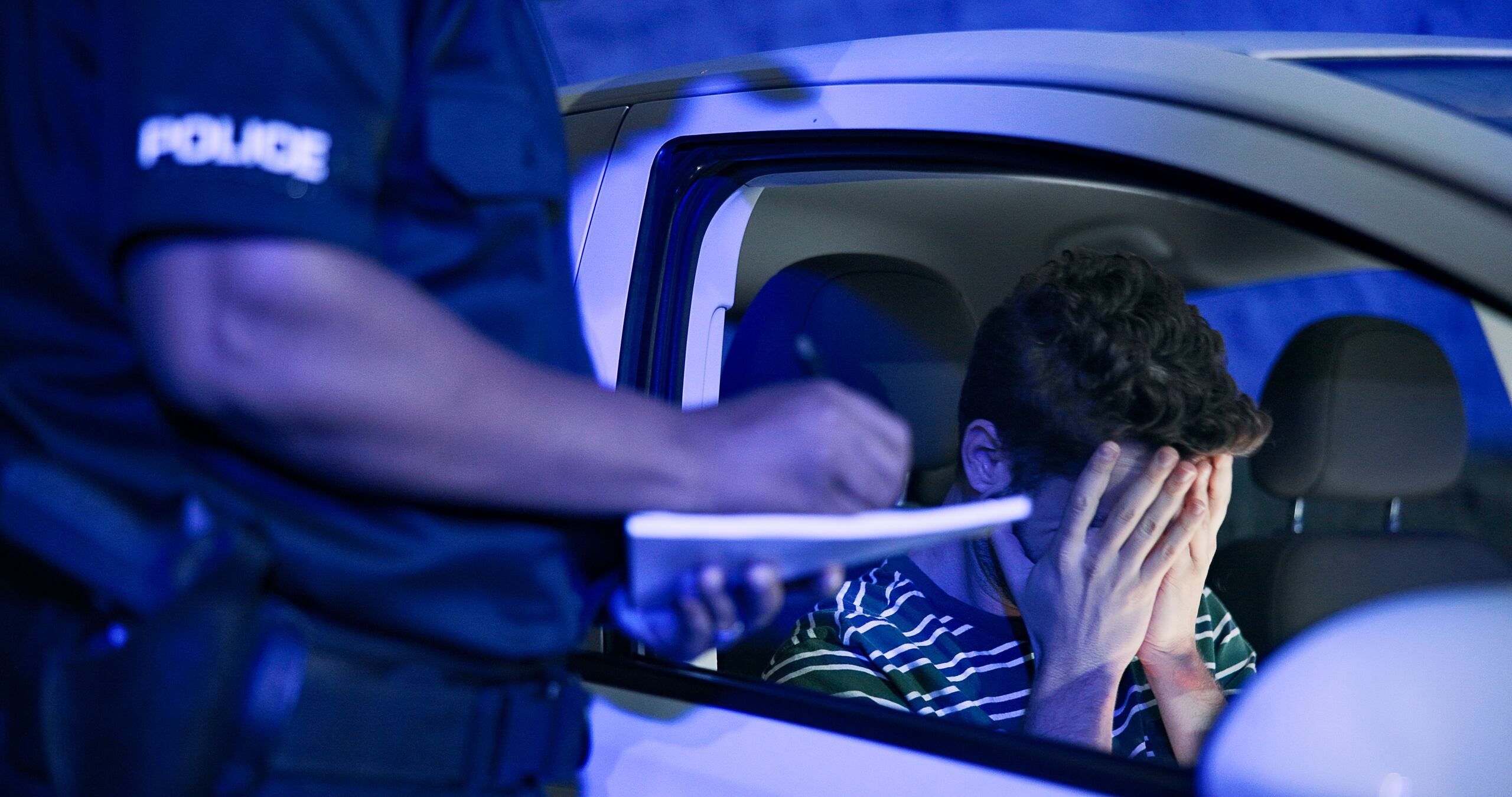 A police officer writes a report during a night traffic stop handled by Anaheim drunk driving accident lawyers.