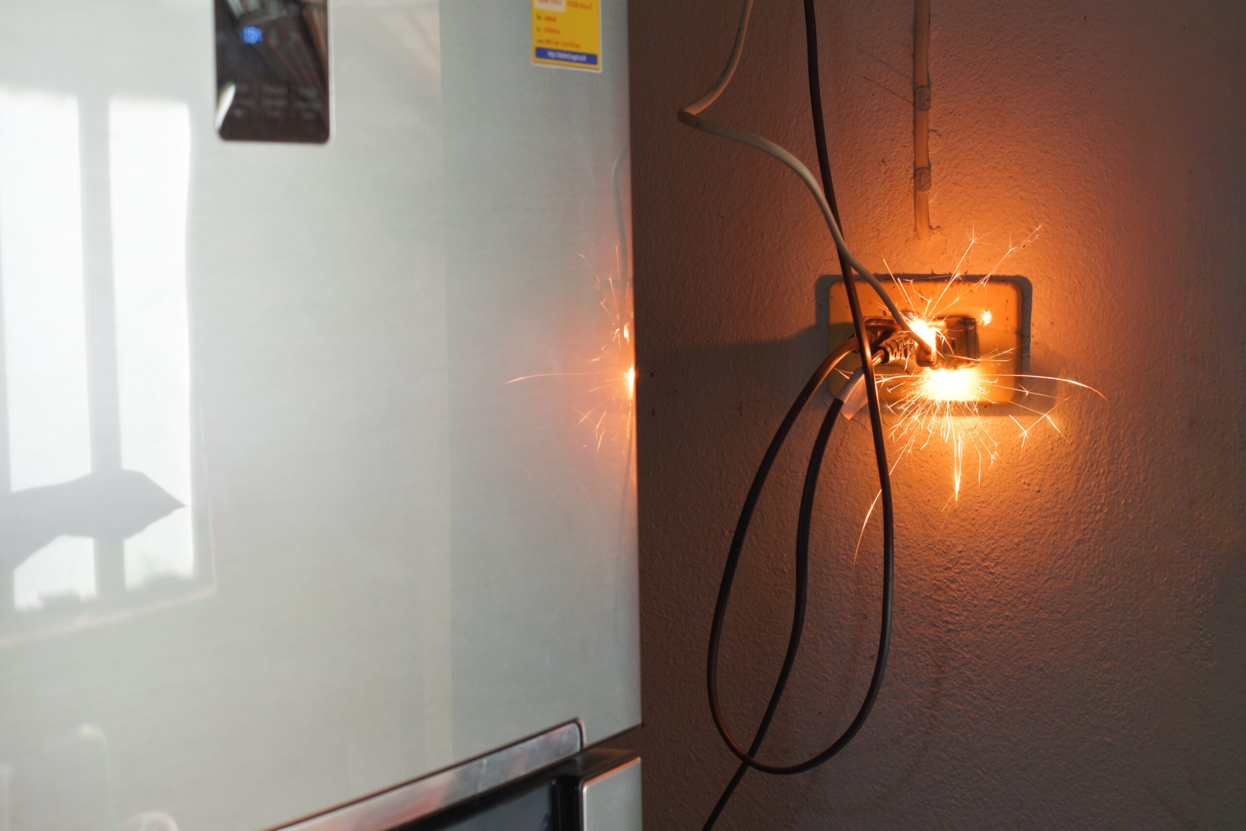 Defective electrical wall outlet sparking next to an appliance illustrating cases represented by Anaheim product liability lawyers.