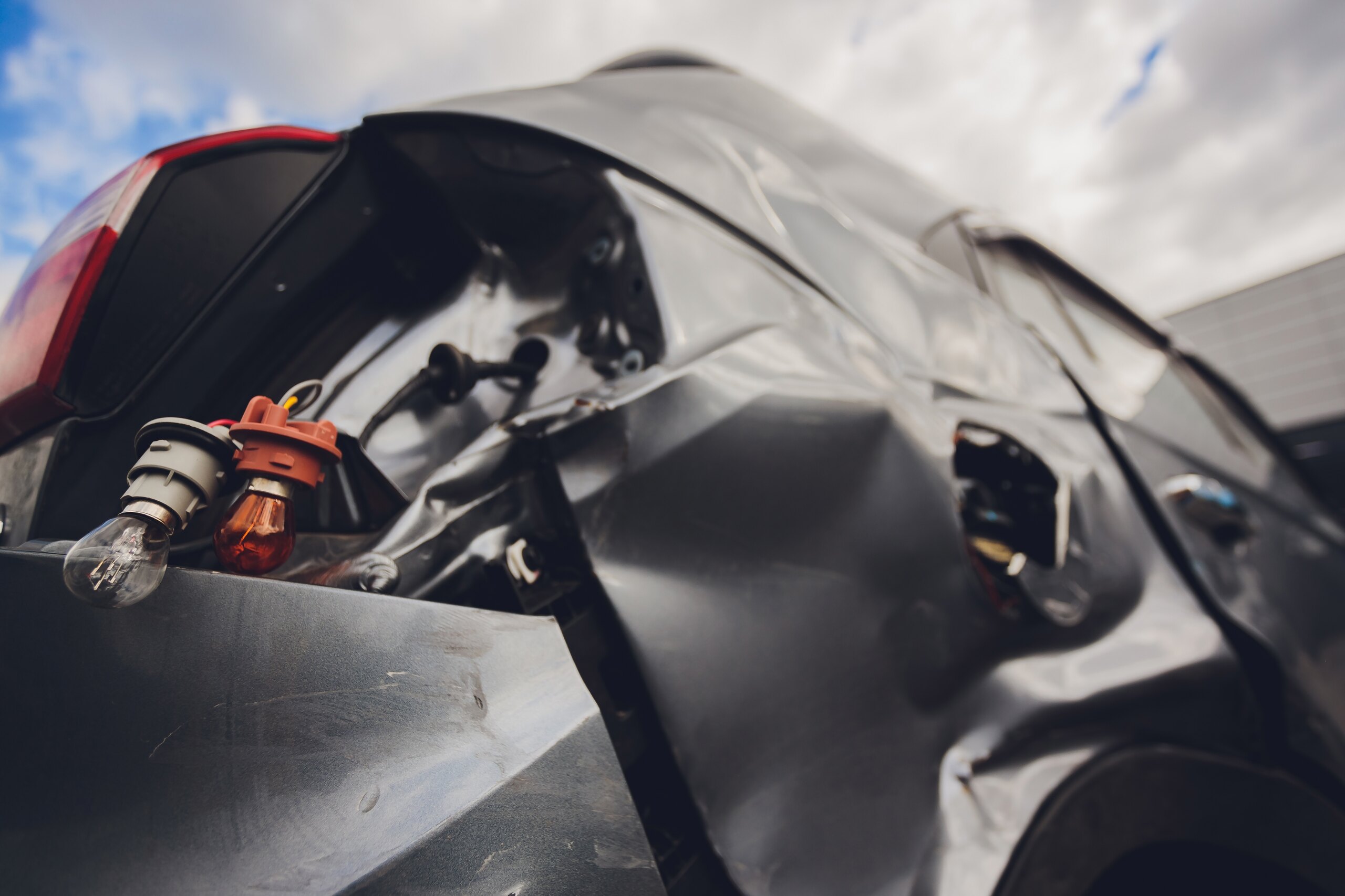 A smashed vehicle rear with exposed taillight wires reviewed by Burbank car accident lawyers.