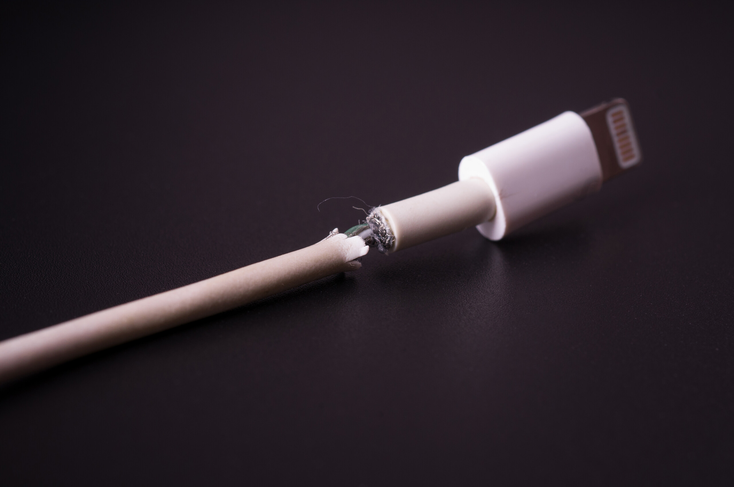 A frayed charging cable shows exposed wires, a defect evaluated by Los Angeles product liability attorneys.
